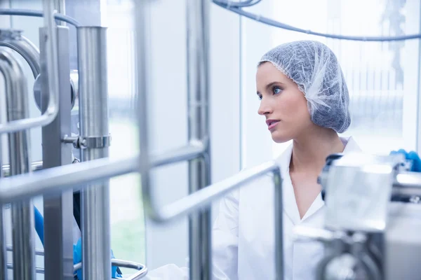 Portrait of a smiling scientist behind metal pipe — Stock Photo, Image