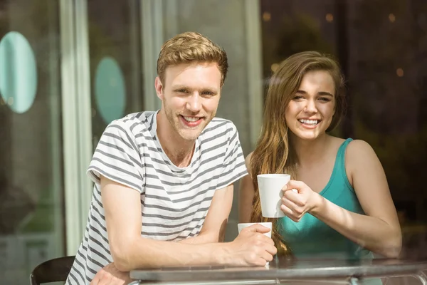 Lachende vrienden houden mok van koffie — Stockfoto