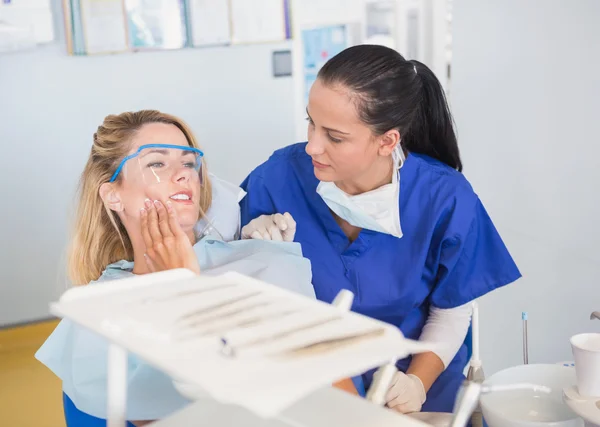 Patient and dentist talking about her toothache — Stock Photo, Image