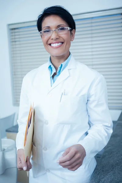 Усміхнена жінка-стоматолог тримає теку — стокове фото