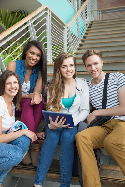 Usmívající se studenti sedí na schodech s tablet pc — Stock fotografie