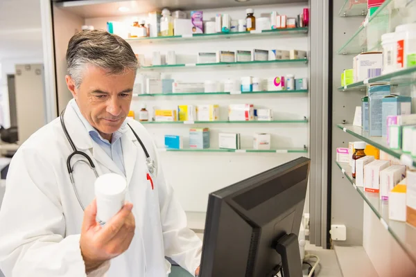 Senior apotheker using naar de computer — Stockfoto