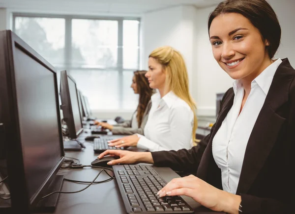Happy woman in computer room smiling at camera — Stock Photo, Image