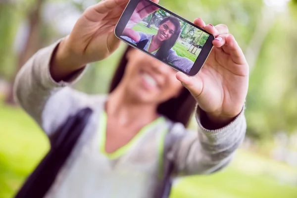 Pretty brunette taking a selfie in park — Stock Photo, Image