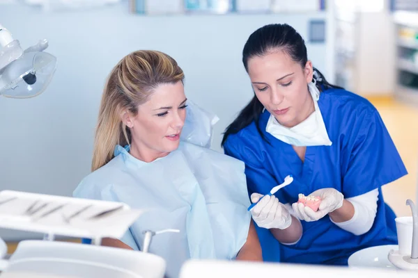 Zahnarzt zeigt Patienten Modell der Zähne — Stockfoto