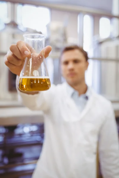 Thoughtful scientist holding a beaker — Stock Photo, Image