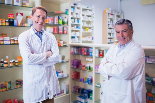 Farmacéuticos sonrientes de pie con los brazos cruzados — Foto de Stock