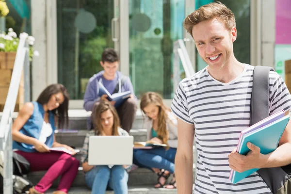 Przystojny student uśmiecha się do kamery na zewnątrz — Zdjęcie stockowe