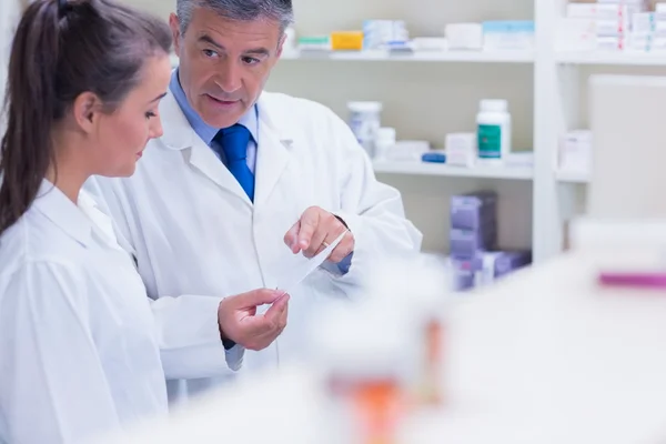 Pharmacist explaining a prescription to his trainee — Stock Photo, Image