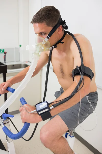 Man doing fitness test on exercise bike — Stock Photo, Image