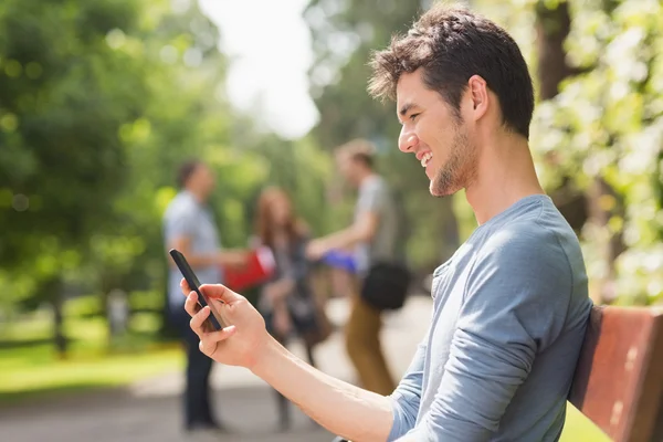 Handsome student sending a text outside — Stock Photo, Image