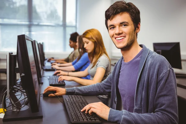 Estudante feliz na aula de informática sorrindo para a câmera — Fotografia de Stock