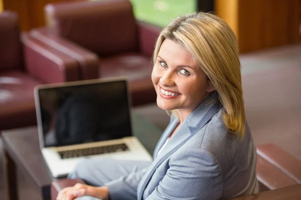 Mujer de negocios rubia sonriendo con el ordenador portátil —  Fotos de Stock