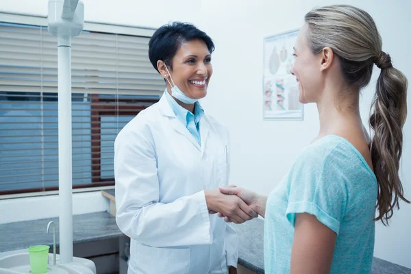 Dentiste femelle serrant la main d'une femme — Photo