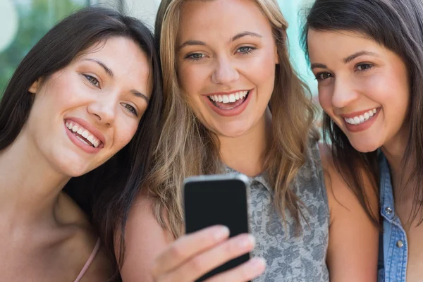 Estudantes felizes olhando para o smartphone fora no campus — Fotografia de Stock