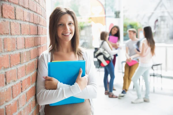 Красивая студентка улыбается и держит блокноты — стоковое фото