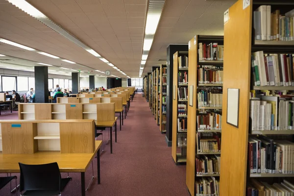 Volymer av böcker på bokhyllan i biblioteket — Stockfoto