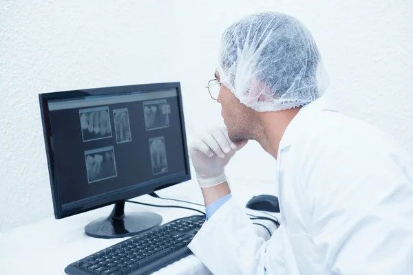 Dentist looking at x-ray on computer — Stock Photo, Image