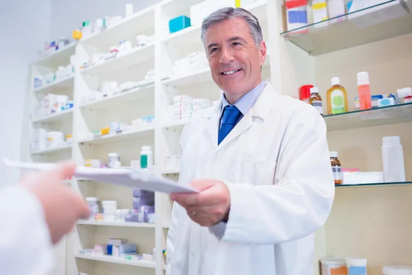 Farmacêutico a dar uma receita a alguém — Fotografia de Stock