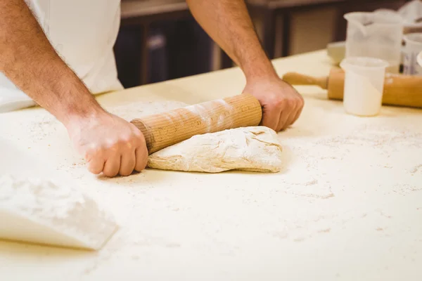 Panettiere rotolando la pasta a un banco — Foto Stock