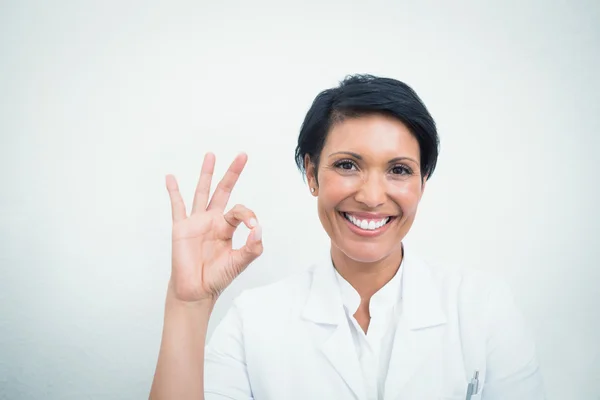 Χαμογελαστά γυναικεία οδοντίατρος χειρονομώ εντάξει σημάδι — Φωτογραφία Αρχείου