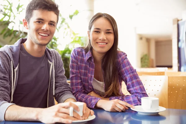 Unga studenter ler mot kameran i café — Stockfoto