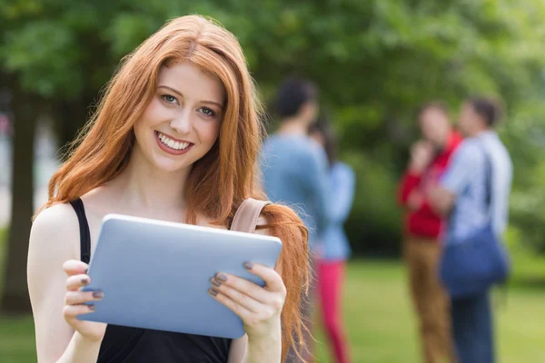 Jolie étudiante souriant à la caméra en utilisant la tablette pc — Photo