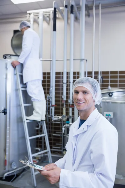 Scientist looking at camera with his colleague behind him — Stock Photo, Image