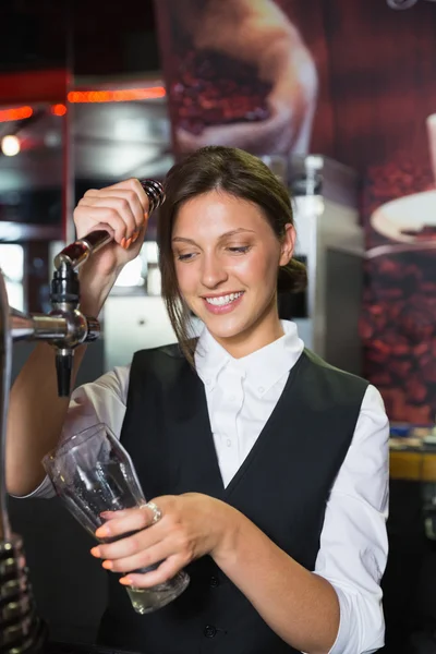 Happy barmanka tahání pintu piva — Stock fotografie