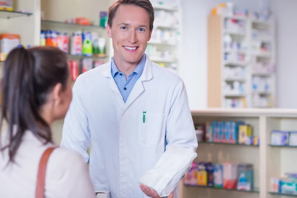 Farmacéutico sonriente sosteniendo una bolsa de papel — Foto de Stock