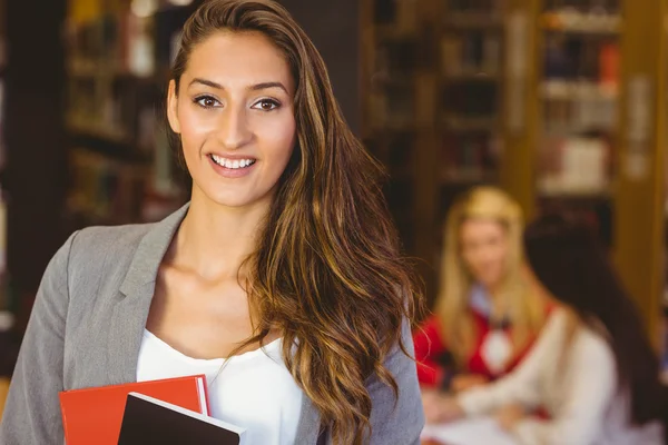 Retrato de una bonita estudiante morena sosteniendo libros — Foto de Stock