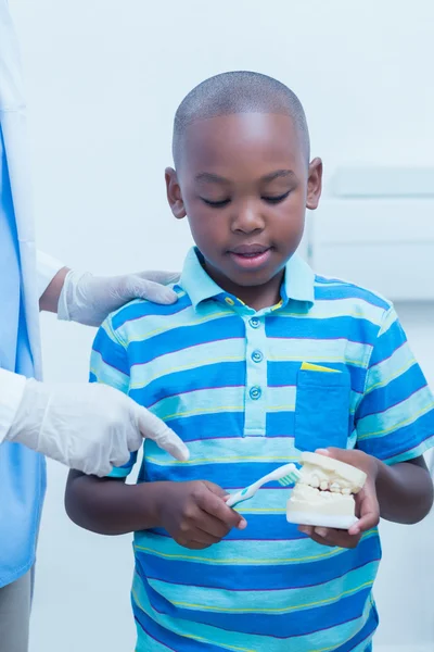 Стоматолог навчає хлопчика чистити зуби — стокове фото