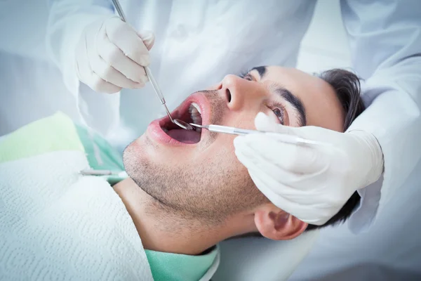 Hombre que tiene sus dientes examinados — Foto de Stock