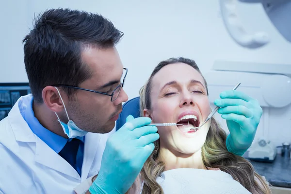 Dentista examinando los dientes de las mujeres jóvenes — Foto de Stock