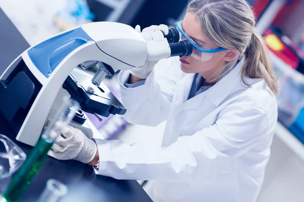 Estudante de ciência olhando através do microscópio no laboratório — Fotografia de Stock