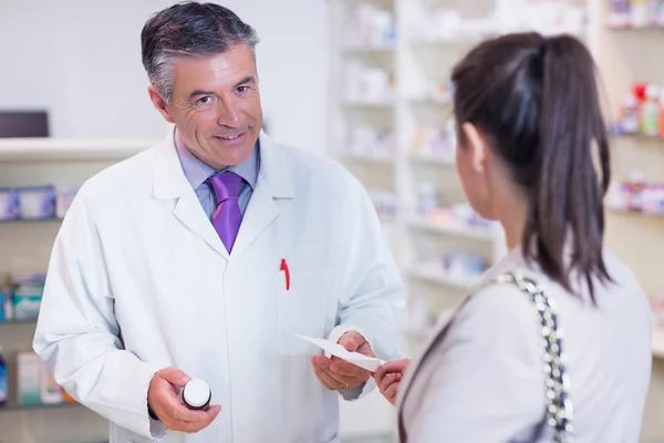 Cliente que entrega una receta a un farmacéutico — Foto de Stock