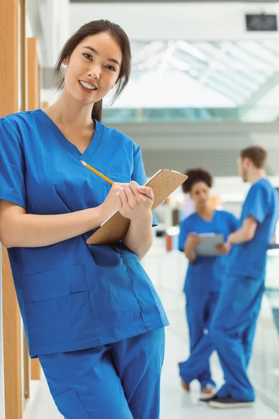 Medical student taking notes in hallway — Stock Photo, Image