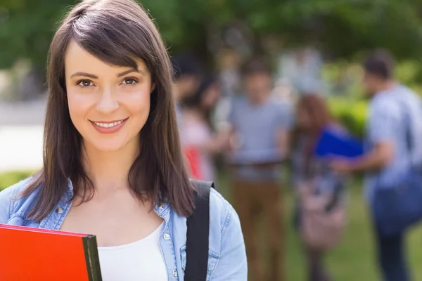 Estudiante bonita sonriendo a la cámara afuera en el campus — Foto de Stock