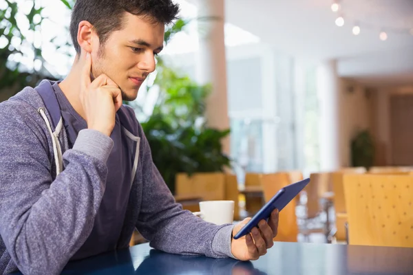 Young student using his tablet in cafe — Stock Photo, Image