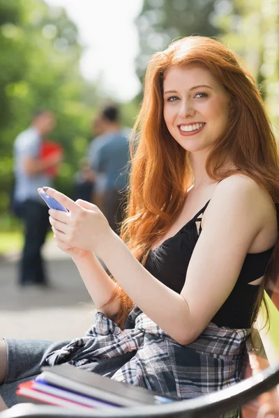 Hübsche Studentin schickt einen Text nach draußen — Stockfoto