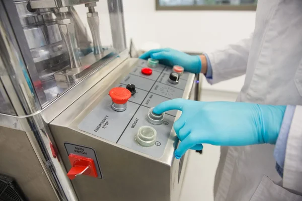 Pharmacist using machinery to make medicine — Stock Photo, Image