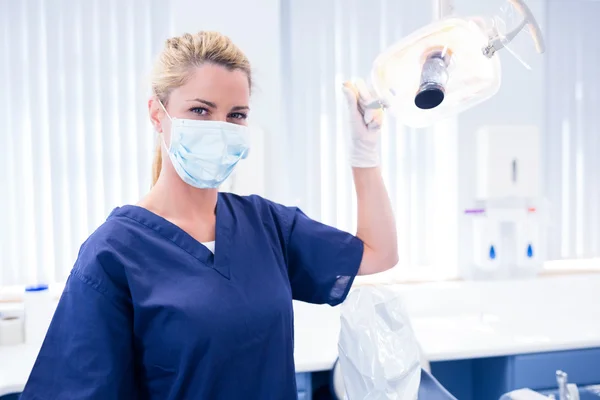 Dentist in mask holding light — Stock Photo, Image