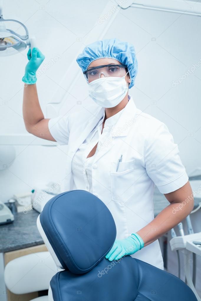 Female dentist wearing surgical mask and safety glasses Stock Photo by ©Wavebreakmedia 65279519