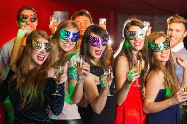 Friends in masquerade masks drinking champagne clipart