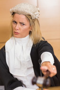 Stern judge pointing her hammer clipart