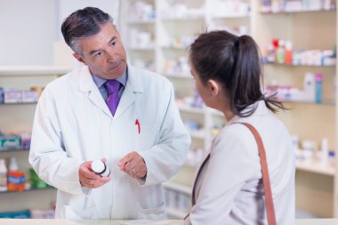 Pharmacist holding a bottle of drugs clipart