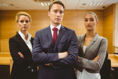 Three serious lawyers standing with arms crossed clipart