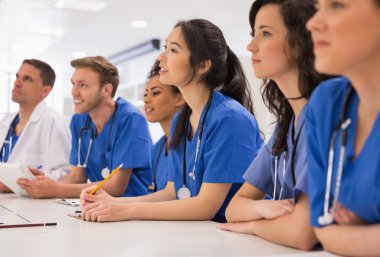 Medical students listening sitting at desk clipart