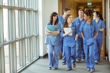 Medical students walking through corridor clipart