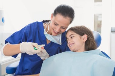 Dentist explaining to young patient clipart